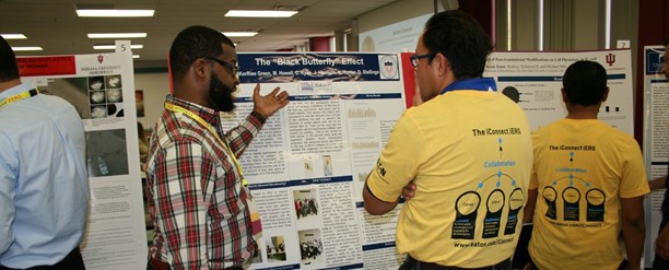 A student is presenting his  research to an employee at Eaton Tech Poster Competition.